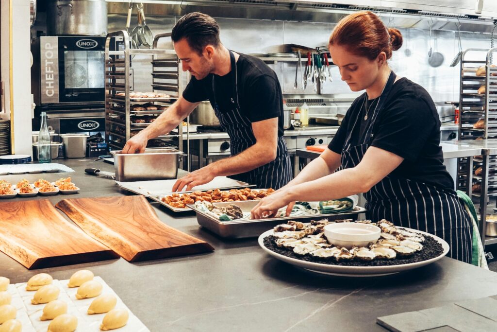 pexels-photo-2696064-2696064 Two chefs working together in a professional kitchen, preparing gourmet dishes with precision.